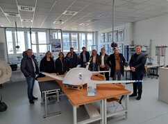 Gruppenfoto mit dem Modell der Transportdrohne Trogon