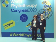 Die beiden Forscherinnen stehen vor einem Ankündigungsplakat zum Weltkongress in...