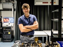 Johann Danzl lächelnd im ISTA Lab mit verschränkten Armen