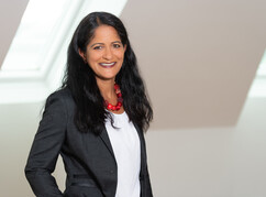 Portraitbild von Sonja Sheikh, sie trägt ihre langen schwarzen Haare offen, hat...