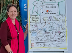 Petra Plicka steht neben ihrem Plakat das die Einleitung zur Aktionswoche...