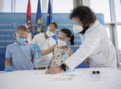 Kinder experimentieren unter Anleitung eines Wissenschaftlers